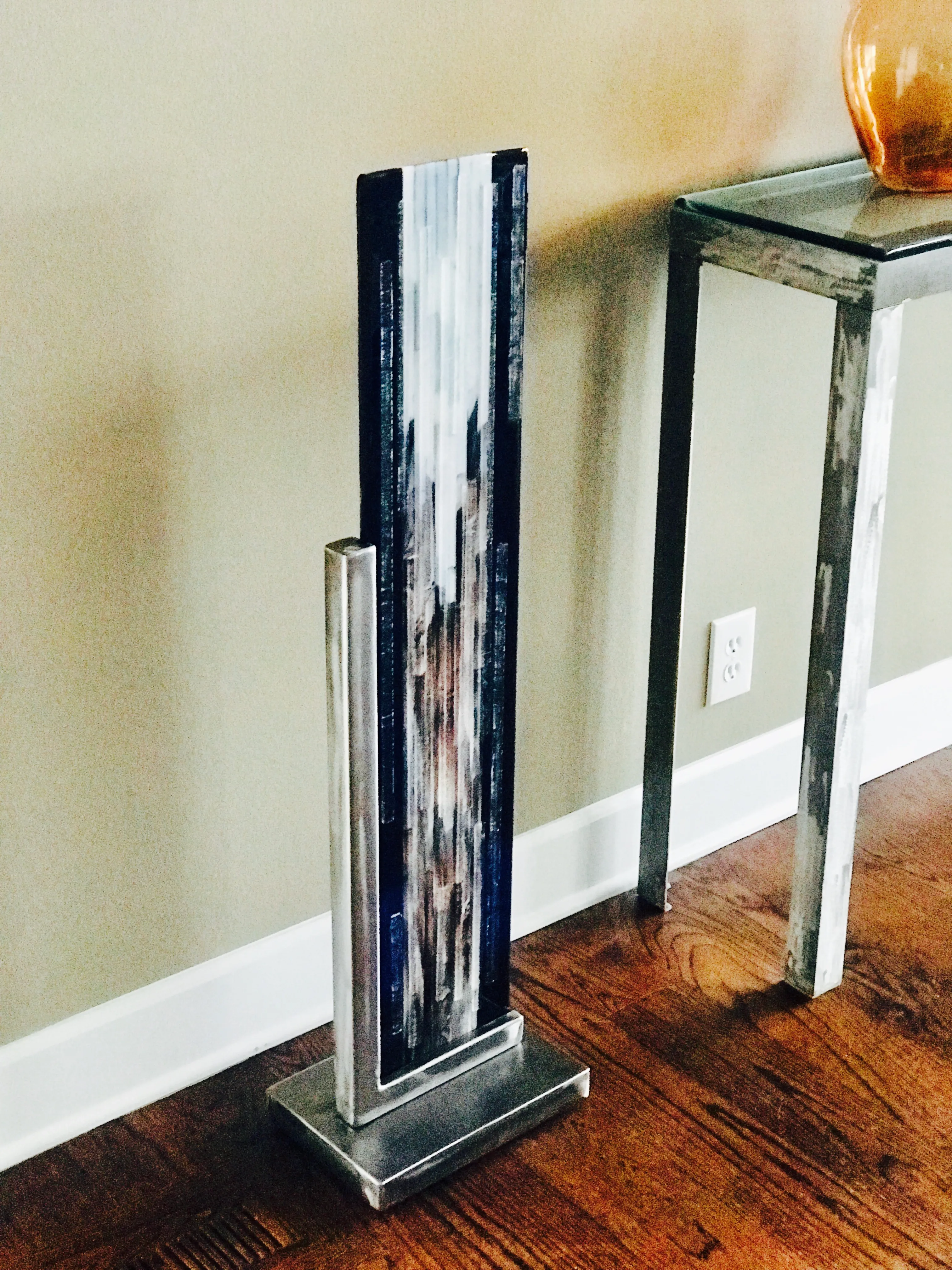 Metal and glass art combining bold metalwork with vibrant glass